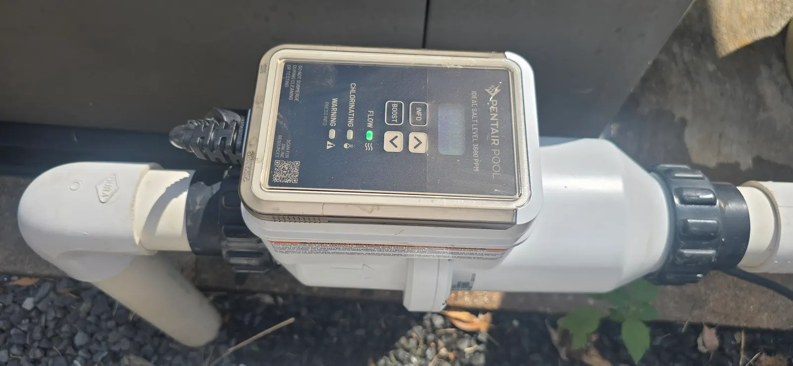 Salt chlorine generator with status lights installed on a pool equipment pad in Greater Houston